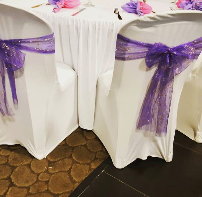 Table de mariage habillée de blanc et de nœuds violets